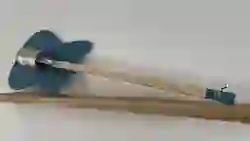 Eine Dosengitarre mit einer Konservendose als Korpus und einem Holzgriffbrett, die auf einem Tisch liegt.